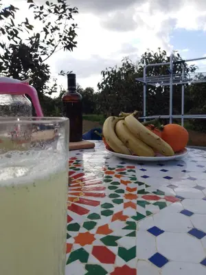 a table with a plate of bananas and a glass of milk at le Cabanon Beldi in Rabat