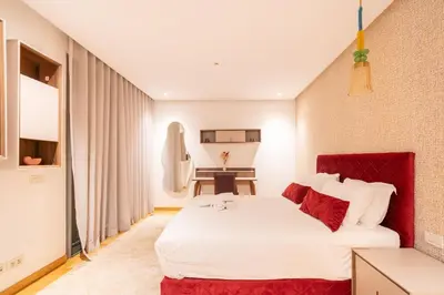 a bedroom with a large white bed with red accents at Marina Vacation Homes in Casablanca