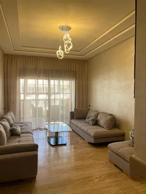 a living room with two couches and a glass table at Appartement Èlégant Vue piscine in Casablanca