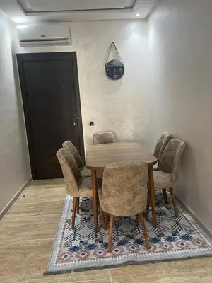 a dining room with a wooden table and chairs at Appartement Èlégant Vue piscine in Casablanca