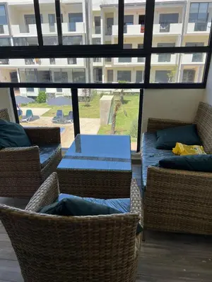 a room with wicker chairs and a table with a blue table at Appartement Èlégant Vue piscine in Casablanca