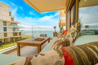 a living room with a table and a view of the ocean at escapade de luxe face a la mer in Rabat