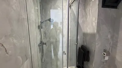 a person taking a picture of a shower in a bathroom at Between sea and historic center in Rabat