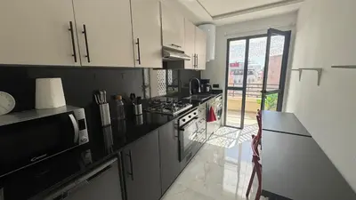 a kitchen with black and white appliances and a counter at Between sea and historic center in Rabat
