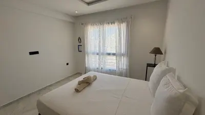 a white bed with a towel on it in a bedroom at Between sea and historic center in Rabat