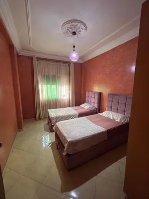 a bedroom with two beds and a couch in it at Cozy apartment in Skhirat near Rabat in Skhirat