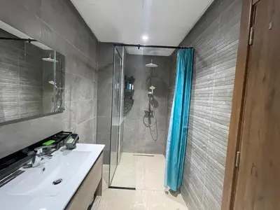 a bathroom with a shower with a sink and a shower curtain at Solstice 73 Luffy Air Studio in Casablanca