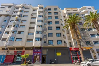 a large building with palm trees in front of it at Solstice 73 Luffy Air Studio in Casablanca
