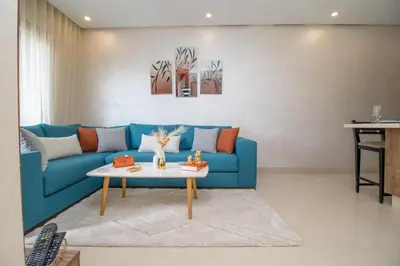 a living room with a blue couch and a table at Studio élégant et neuf près de la gare tgv in Casablanca