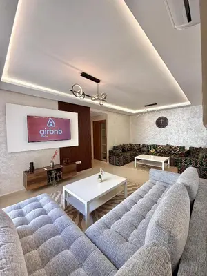 a living room with a couch and a tv at N22 Élégance et Confort à La Corniche Rabat - Appartement de Luxe Essabah in Rabat