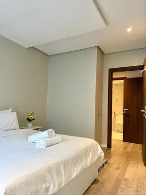 a bedroom with a bed with two towels on it at N22 Élégance et Confort à La Corniche Rabat - Appartement de Luxe Essabah in Rabat