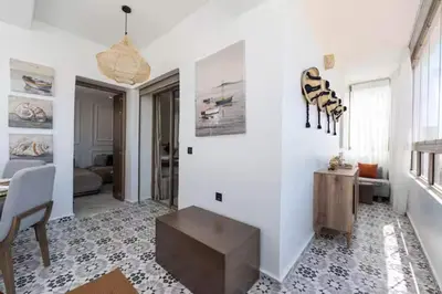 a living room with white walls and a table at Mansouria 1BR Pool View Beach Parking in Mansouria