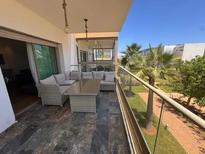 a patio with a couch and a table on a balcony at Blue Beach in Casablanca
