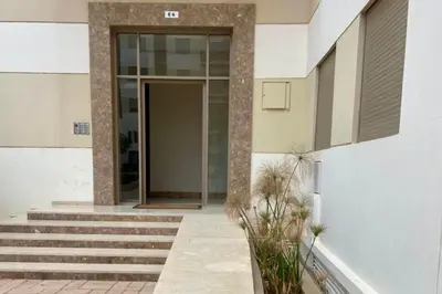 a building with stairs and a glass door at Appartement Moderne et Équipé Proche Aéroport CMN in Nouaseur