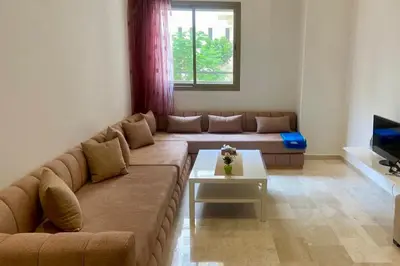 a living room with a couch and a table at Appartement Moderne et Équipé Proche Aéroport CMN in Nouaseur