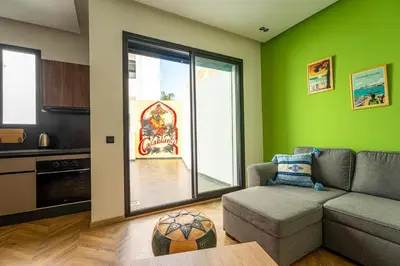 a living room with a couch and a kitchen at Graffiti Chill Zone - Calme en plein Centre in Casablanca