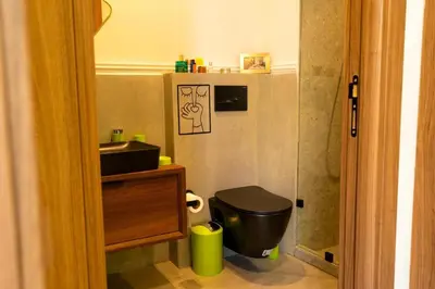 a bathroom with a black toilet and a sink at Graffiti Chill Zone - Calme en plein Centre in Casablanca