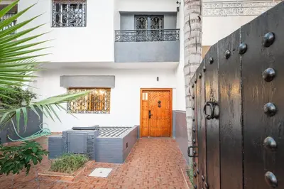 a building with a orange door and a brick walkway at Harhoura Luxury Stay, Steps from the Beach in Temara