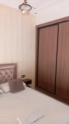 a bedroom with a large bed with a large wooden door at Casa Comfort Apartment in Casablanca