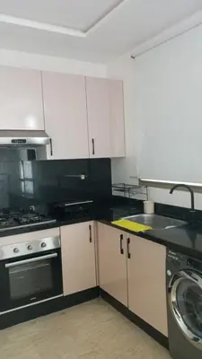a kitchen with white cabinets and a sink and a dishwasher at Casa Comfort Apartment in Casablanca