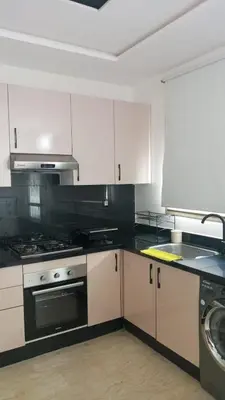 a kitchen with white cabinets and a stove top oven at Casa Comfort Apartment in Casablanca
