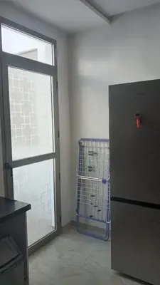 a kitchen with a refrigerator and a large window at Casa Comfort Apartment in Casablanca