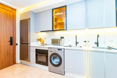 a kitchen with white cabinets and a washer and dryer at Cozy and new apartment in Princesses in Casablanca