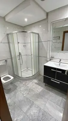 a bathroom with a shower and a toilet and a sink at Villa piscine in Temara