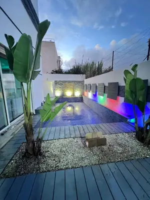 a swimming pool with lights on the side of a building at Villa piscine in Temara