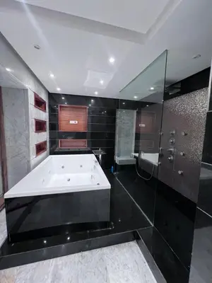 a large bathroom with a bath tub and glass walls at Villa piscine in Temara