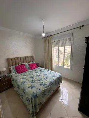 a bedroom with a bed with pink pillows and a window at Appartement serein & apaisant in Bouznika