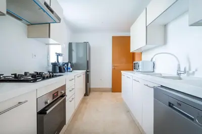 a kitchen with white cabinets and a stove top oven at Luxury 3 Bedroom Apartment in the Heart of CFC with Swimming pool in Casablanca