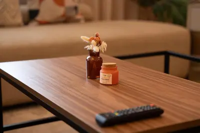 a bottle of honey next to a remote control on a table at Luxury 3 Bedroom Apartment in the Heart of CFC with Swimming pool in Casablanca