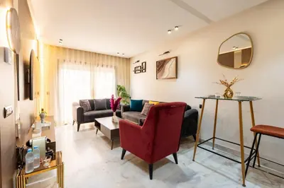a living room with a couch and a red chair at Awesome place with city view maarif casablanca in Maarif