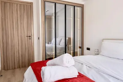 a bedroom with a white bed and a red rug at Awesome place with city view maarif casablanca in Maarif