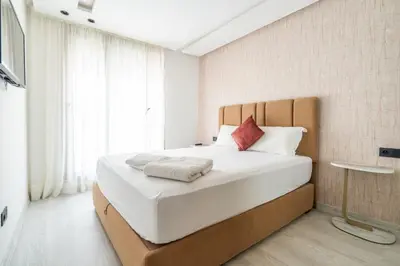 a bedroom with a large bed with white sheets and red pillows at Les Princesses - 2BR - Balcony - New Residence - Parking - DAR & STAY in Casablanca