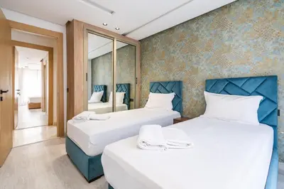 two beds in a room with a mirror at Les Princesses - 2BR - Balcony - New Residence - Parking - DAR & STAY in Casablanca
