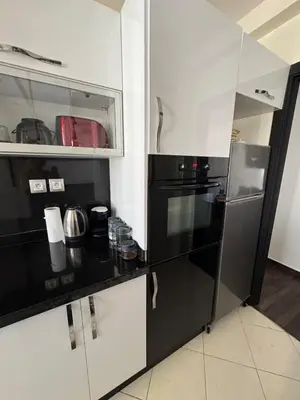 a kitchen with a black and white refrigerator at chambre saada in Dar Bouazza