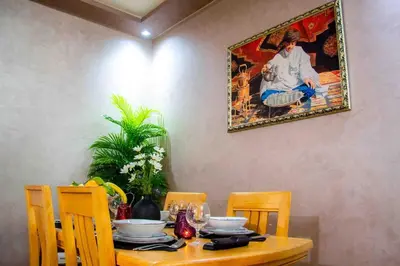 a dining room table with a painting hanging on the wall at Centre rabat agdal 10min of stade molay aabdellah in Rabat