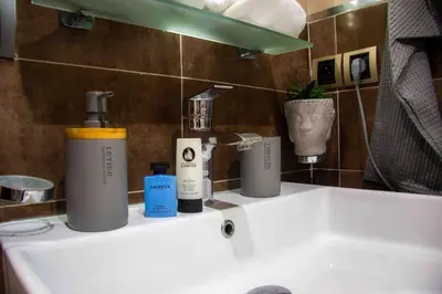 a bathroom sink with two bottles ofodorizers on it at Centre rabat agdal 10min of stade molay aabdellah in Rabat