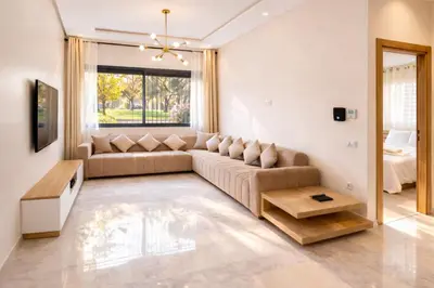 a living room with a couch and a table at Cozy Apartment Near Airport in Nouaceur