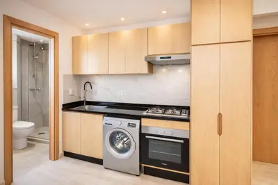 a kitchen with a stove and a washing machine at Cozy Apartment Near Airport in Nouaceur