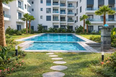 a swimming pool in front of a building at Cozy Apartment Near Airport in Nouaceur