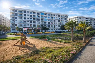 a playground in a park in front of a building at Cozy Apartment Near Airport in Nouaceur