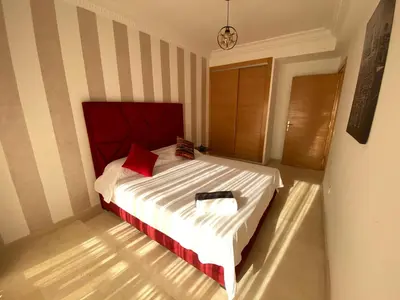 a bedroom with a large white bed with red pillows at Bourgogne Ocean Prestige in Casablanca