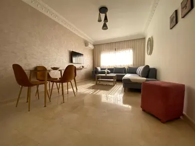 a living room with a couch and a table and chairs at Bourgogne Ocean Prestige in Casablanca