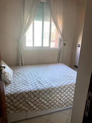 a bed in a room with a window at Appartement à louer à Mansouria in Mansouria