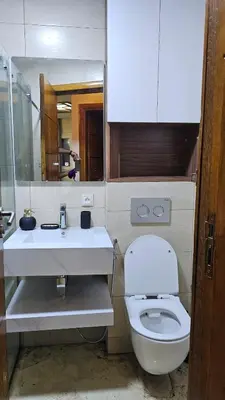 a bathroom with a white toilet and a sink at Modern and cozy - Central apartment in Casablanca in Casablanca