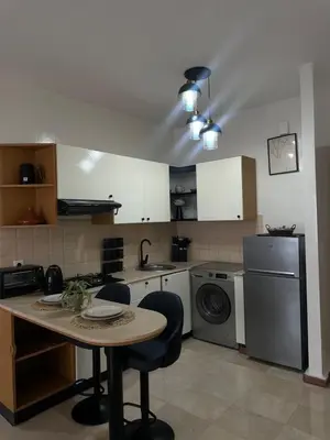 a kitchen with a table and a washer and dryer at Cozy stylish Studio in downtown Casablanca in Casablanca