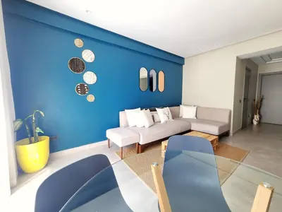 a living room with a blue wall and a couch at The 41 Maarif by IB Signature - Boho Chic 1BR Apt - with Wifi - Self check-in - 24 x7 Security - City View with terrace - Walk to Cafes! City Centre in Casablanca